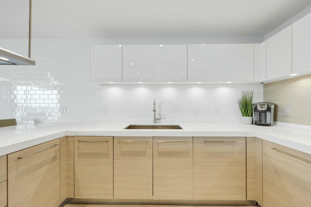 kitchen with sink, stainless steel oven, light brown cabinets, black electric cooktop, and island exhaust hood