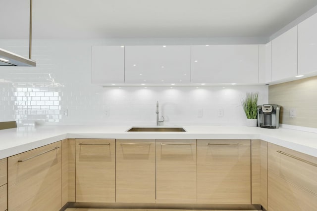 kitchen with light brown cabinetry, modern cabinets, light countertops, and a sink