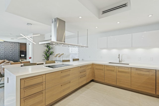 kitchen featuring sink, white cabinetry, island range hood, black electric cooktop, and backsplash