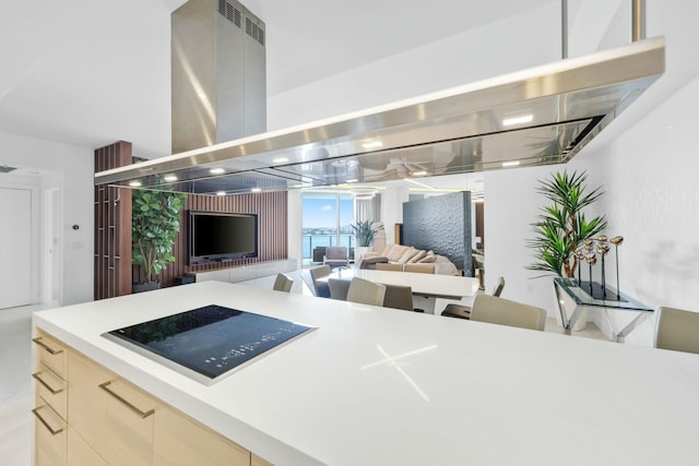 kitchen with open floor plan, island exhaust hood, modern cabinets, and light countertops