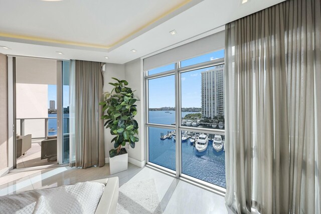 bedroom featuring expansive windows and a water view