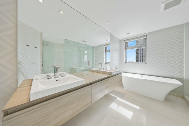 bathroom with a freestanding tub, a stall shower, wallpapered walls, tile patterned flooring, and double vanity