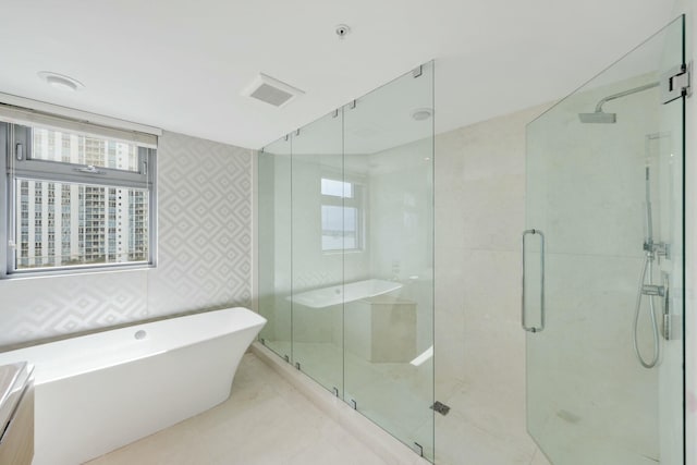 bathroom with visible vents, a soaking tub, and a shower stall