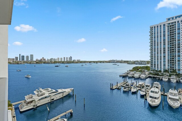 view of water feature with boat lift, a city view, and a dock