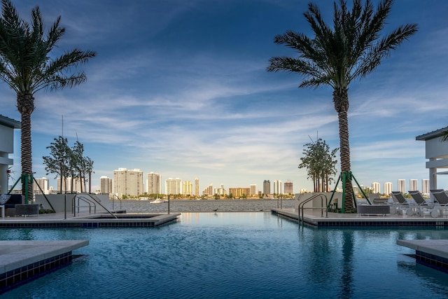 view of pool with a city view and a water view
