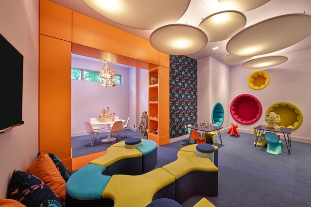 rec room with baseboards, carpet floors, and a chandelier