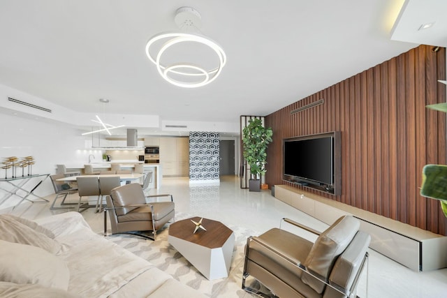 living room with an inviting chandelier and wood walls