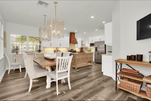 dining space featuring dark wood-type flooring and a notable chandelier