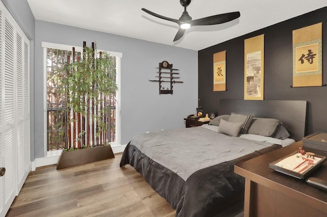 bedroom with hardwood / wood-style flooring, ceiling fan, and a closet