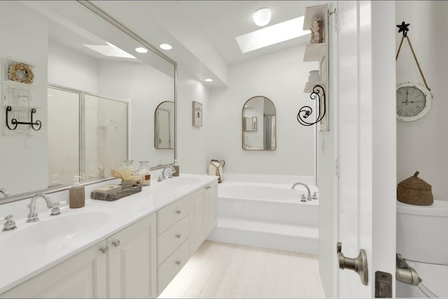 full bathroom featuring a skylight, independent shower and bath, tile patterned flooring, vanity, and toilet