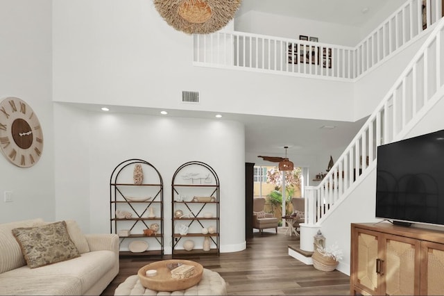 living room with a towering ceiling and dark hardwood / wood-style floors