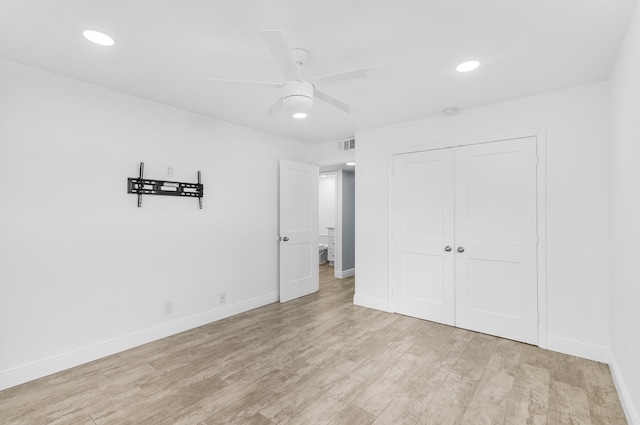 unfurnished bedroom featuring ceiling fan, a closet, and light wood-type flooring