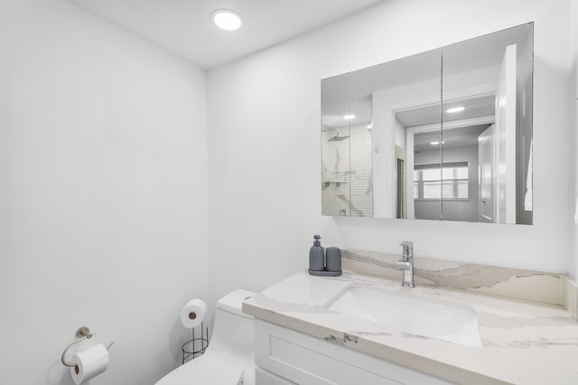 bathroom featuring recessed lighting, vanity, toilet, and a shower stall