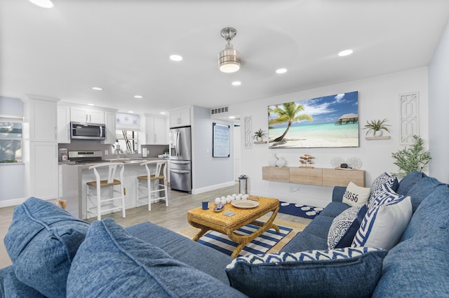 living area featuring light wood-type flooring, visible vents, baseboards, and recessed lighting