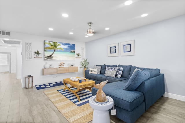 living room with baseboards, visible vents, wood finished floors, and recessed lighting