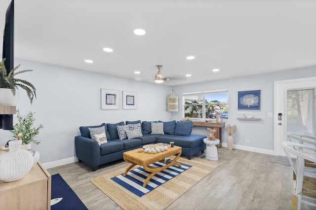 living room featuring light wood-type flooring, baseboards, and recessed lighting