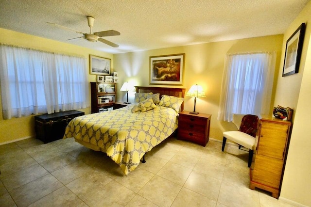 tiled bedroom with ceiling fan and a textured ceiling