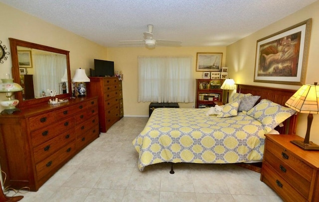 tiled bedroom with ceiling fan and a textured ceiling