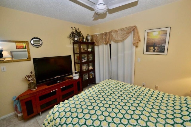 tiled bedroom featuring ceiling fan and a textured ceiling