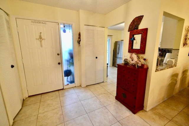 tiled foyer entrance with a textured ceiling