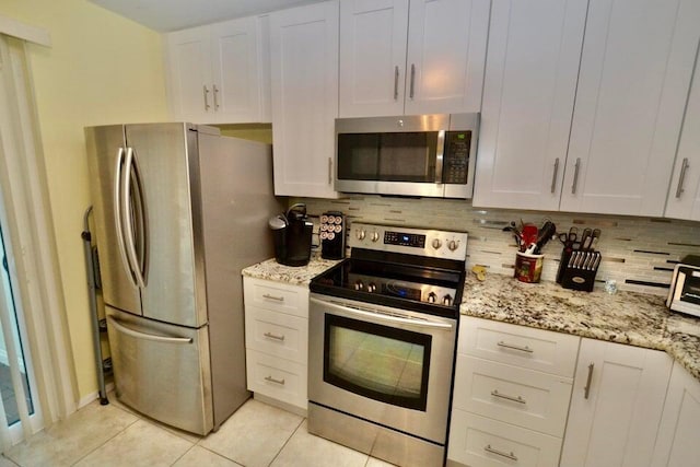 kitchen with stainless steel appliances, decorative backsplash, and white cabinets