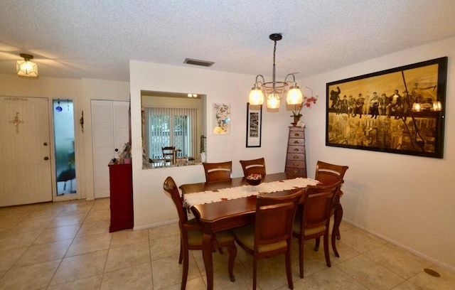 dining area with a textured ceiling and light tile patterned floors