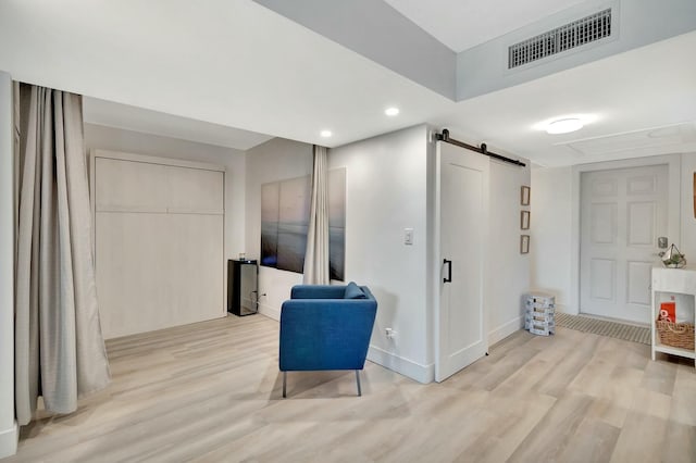 living area featuring a barn door and light wood-type flooring