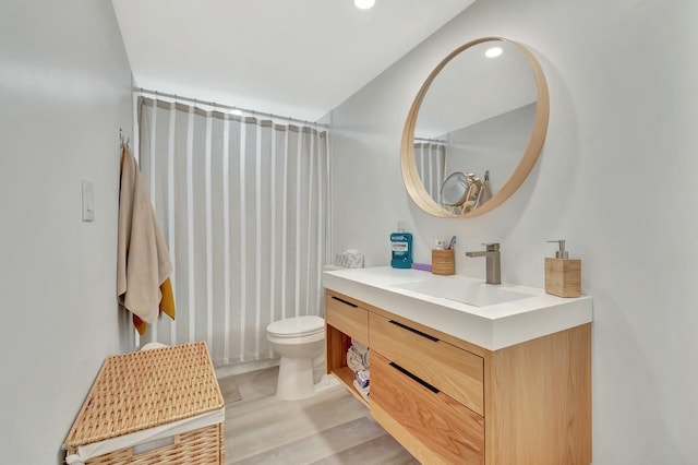 bathroom with vanity, toilet, and wood-type flooring