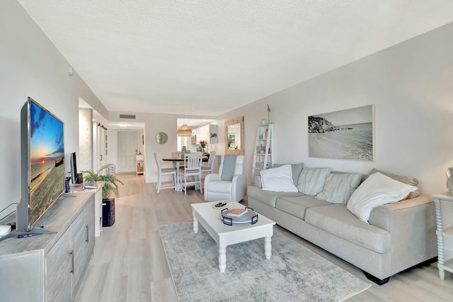 living room featuring light hardwood / wood-style floors and a textured ceiling