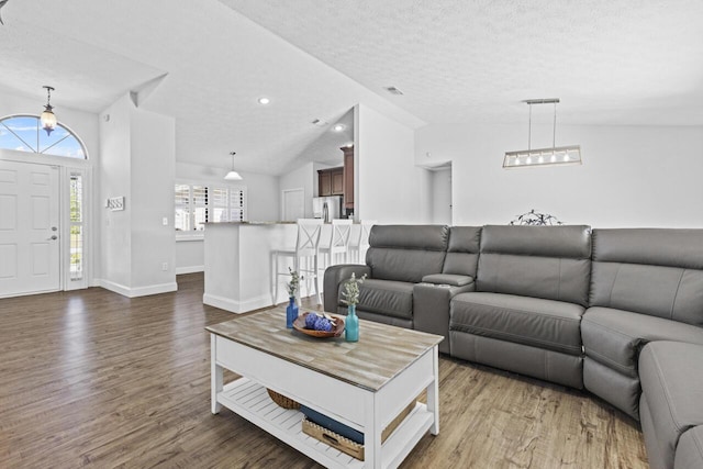 living room with lofted ceiling, dark hardwood / wood-style floors, and a textured ceiling