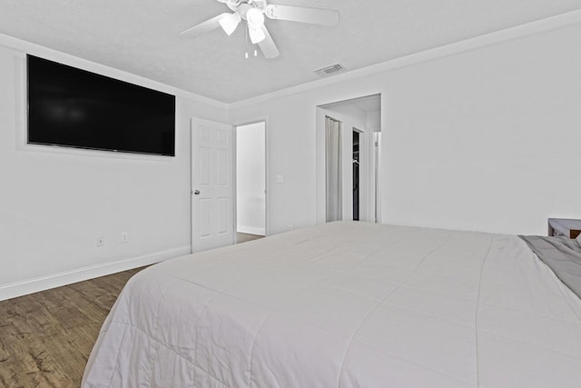 bedroom with ceiling fan, dark wood-type flooring, and a textured ceiling