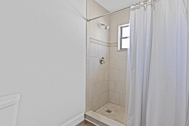 bathroom featuring walk in shower, toilet, and hardwood / wood-style floors