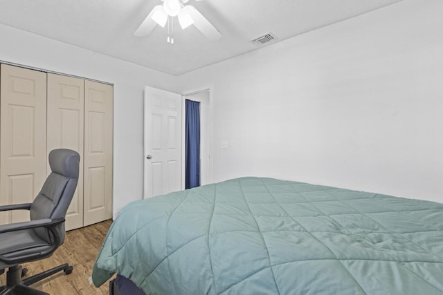 bedroom with hardwood / wood-style flooring, ceiling fan, and a closet