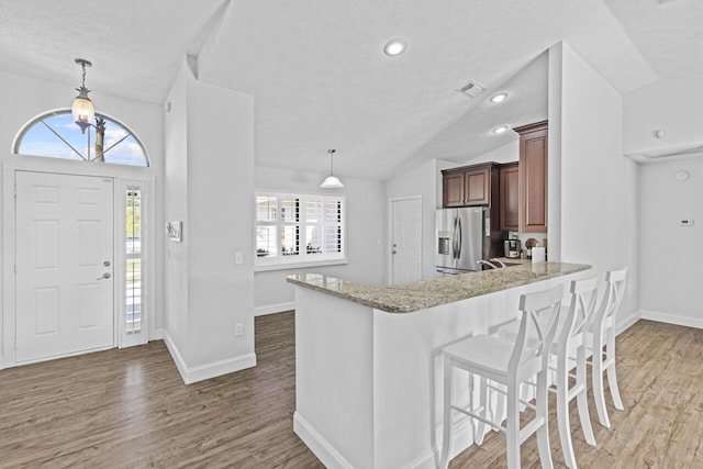 foyer featuring lofted ceiling, sink, hardwood / wood-style floors, and a textured ceiling