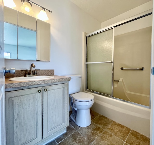 full bathroom featuring enclosed tub / shower combo, vanity, and toilet