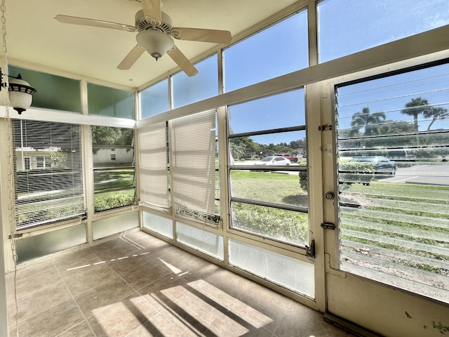 unfurnished sunroom with ceiling fan