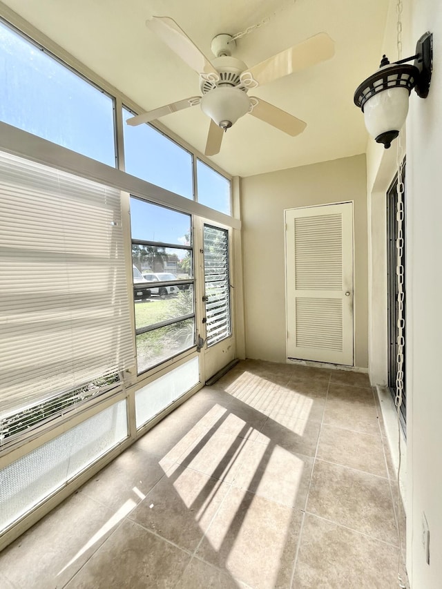 unfurnished sunroom featuring ceiling fan