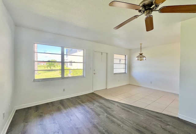 spare room with ceiling fan, light hardwood / wood-style floors, and a textured ceiling