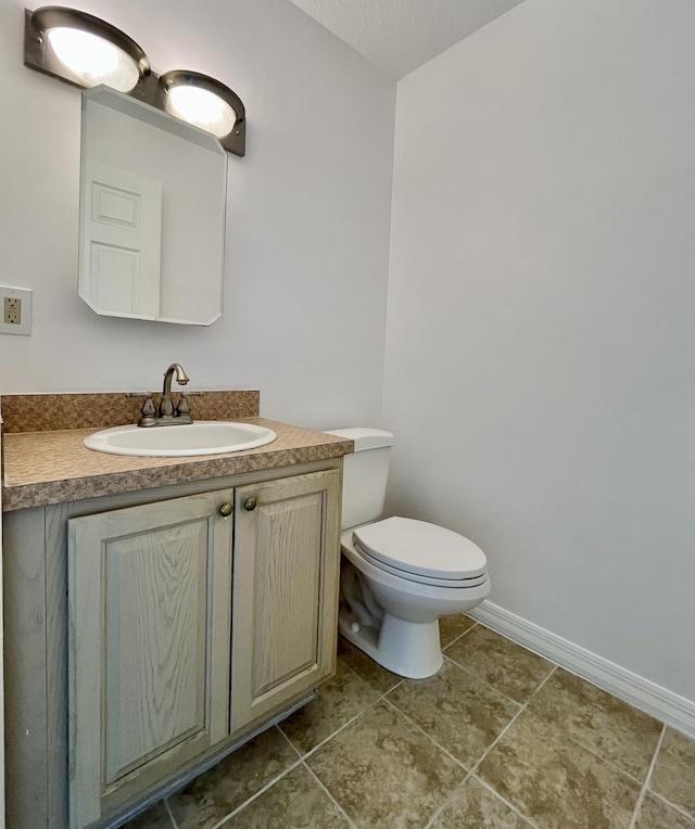 bathroom featuring vanity, toilet, and tile patterned flooring