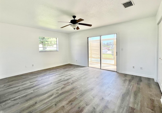 spare room featuring ceiling fan, dark hardwood / wood-style floors, and a textured ceiling