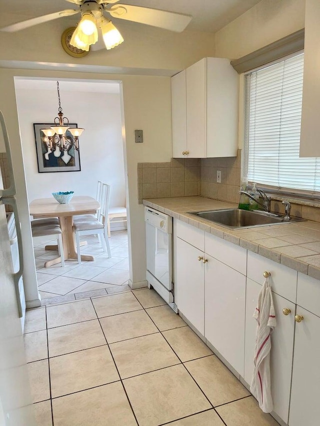 kitchen with white dishwasher, sink, and white cabinets