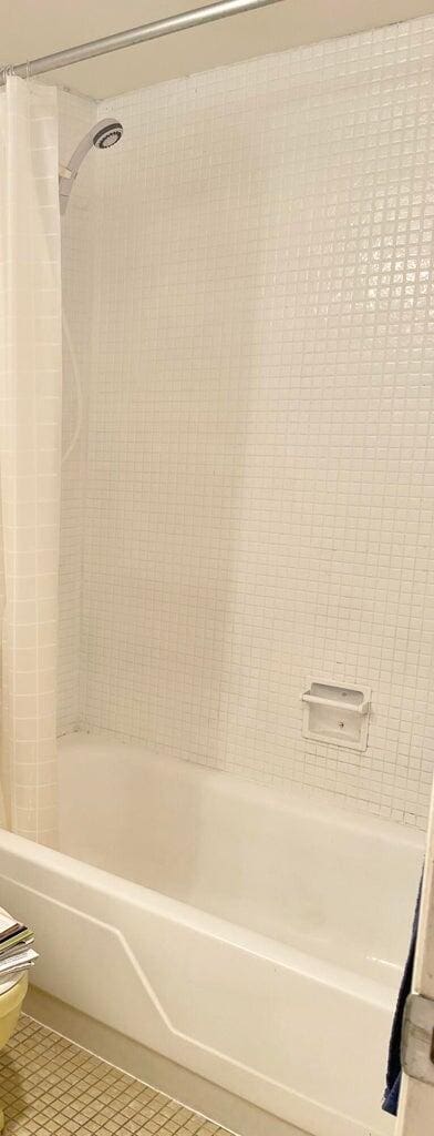 bathroom with shower / tub combo with curtain, toilet, and tile patterned flooring