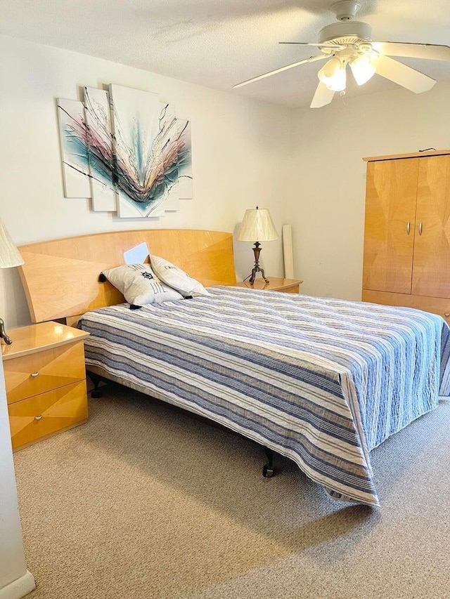 bedroom featuring carpet flooring, a textured ceiling, and ceiling fan