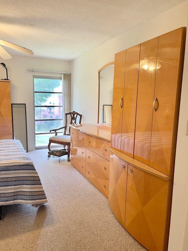 bedroom featuring ceiling fan, carpet flooring, and a textured ceiling