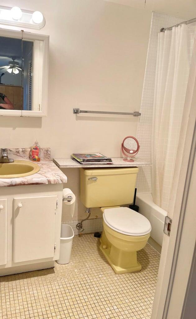 full bathroom with vanity, shower / bathtub combination with curtain, and toilet