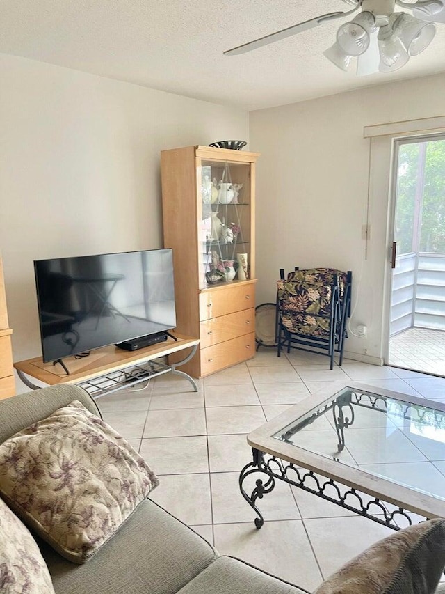 tiled living room featuring ceiling fan and a textured ceiling