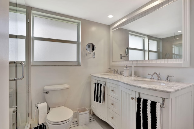 bathroom with walk in shower, vanity, and toilet