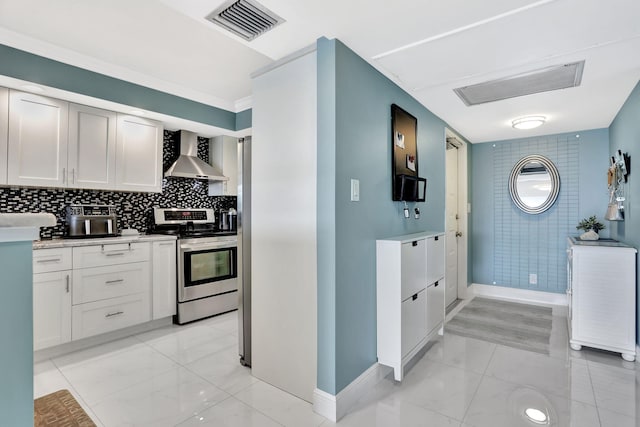 kitchen featuring white cabinetry, stainless steel electric range oven, decorative backsplash, and wall chimney range hood