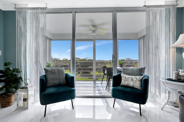 sitting room with light tile patterned floors, a wealth of natural light, expansive windows, and ceiling fan