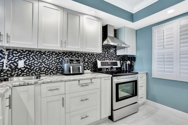 kitchen with white cabinetry, wall chimney range hood, stainless steel electric stove, and ornamental molding